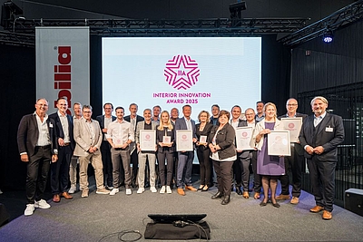 Interior Innovation Award: Die Sieger:innen 2025 stehen auf der Bühne und präsentieren ihre Urkunden