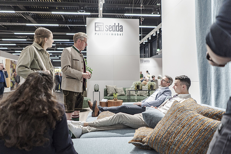 Besucher des Messestandes "sedda" testen eine Couch auf der moebel austria & küchenwohntrends 2023 ©Sascha Bartel